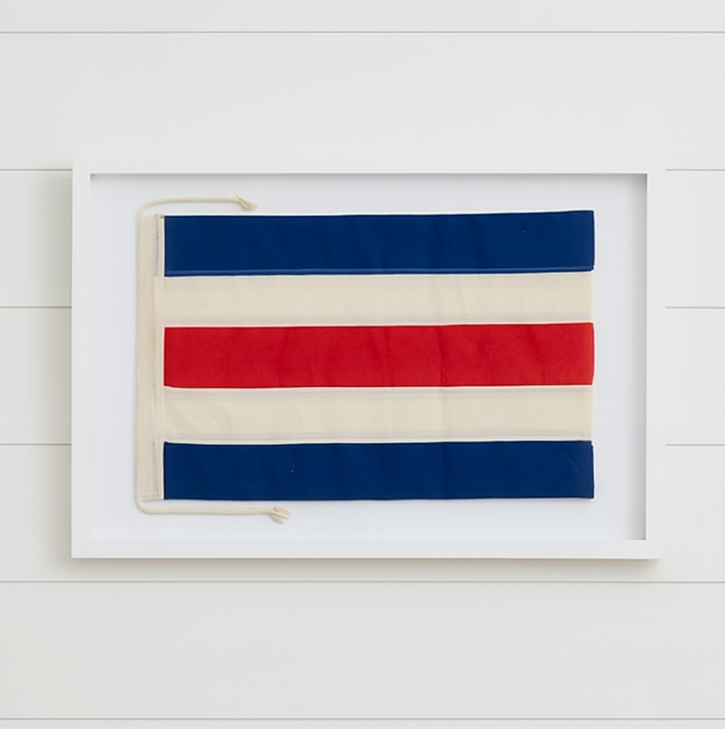 Framed artwork with red, white, and blue stripes on a white wall.
