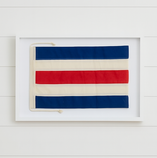 Framed artwork with red, white, and blue stripes on a white wall.