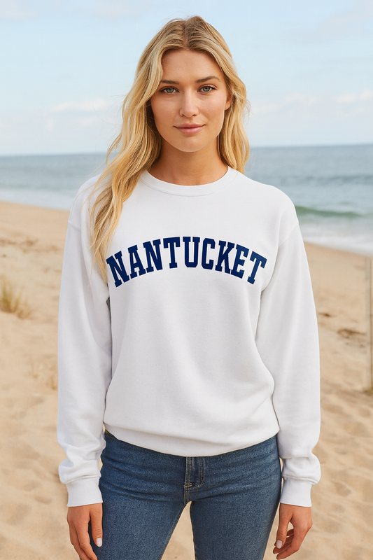 Woman wearing a white sweatshirt with 'NANTUCKET' text on a beach